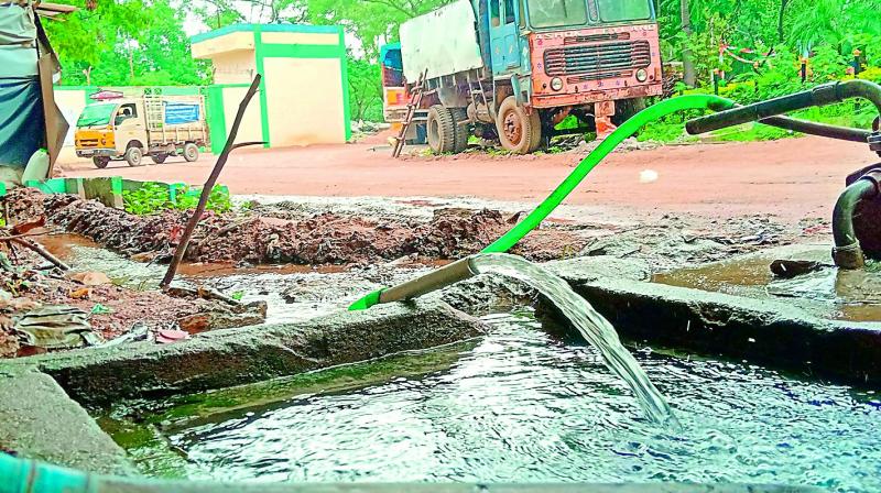 Despite being a holiday on Saturday, water is pumped into the open tank which is seen overflowing at the GHMC circle office in Quthbullapur.