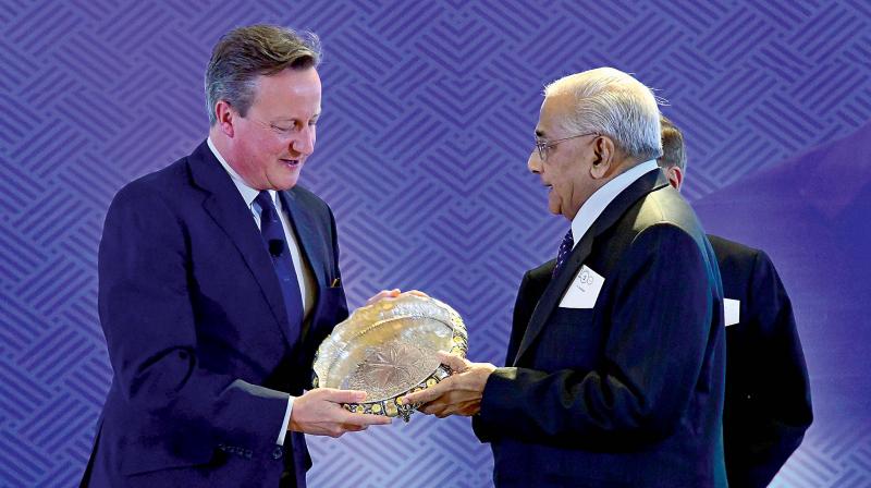Former British Prime Minister David Cameron receives a memento from N.Sankar, son of K.S.Narayanan whose centenary was celebrated in Chennai.