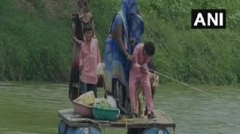 Villagers cross crocodile-inhabited river on boat made of plastic barrels