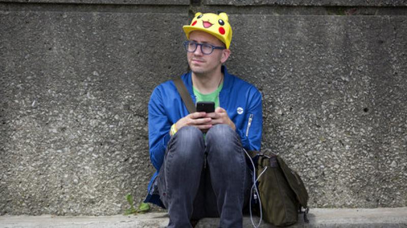 Ryan Copple of Los Angeles sits in the shade as he struggles to play Pokemon Go at the Pokemon Go Fest Saturday, July 22, 2017, at Grant Park in Chicago. (Photo: AP)
