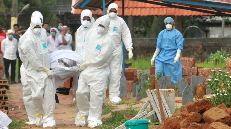 Doctors and relatives, wearing protective gear, carry the body of Valachuketty Moosa, 62, who succumbed to Nipah virus infection at the private Baby Memorial Hospital in Kozhikode on Thursday. The body was buried in a 10-ft-deep tomb at Kannamparambu mosque in Kozhikode. Moosas two sons and sister-in-law had died of the same infection in the past three weeks. (Photo: Venugopal)