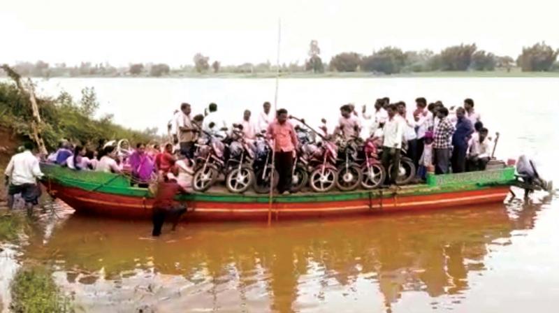 People use boat to cross River Krishna near Jamakandi on Thursday as water level increased 	 (Image: KPN)