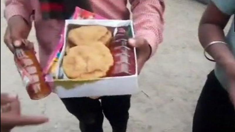 In the video, children are seen showing the liquor bottles placed neatly in the lunch packets. (Photo: ANI | Twitter)