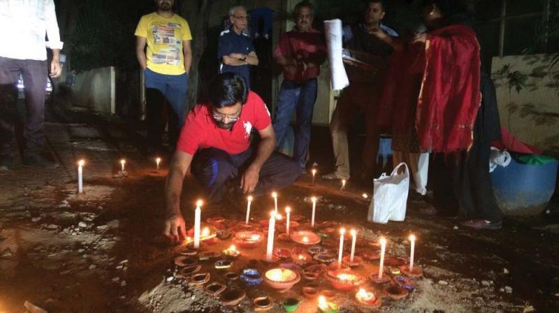 Residents of Swami Vivekananda Road, near Whitefield, light candles in  potholes to protest BBMP apathy in repairing roads.