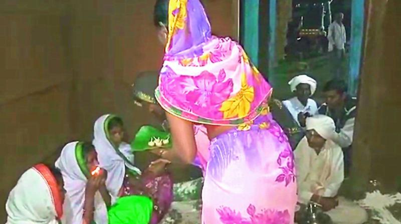 Women swallow lit lamps at a ritual held  at the village headmans house in Kanchanpalli.