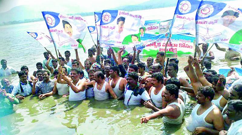 Chandragiri YSR Congress legislator Chevireddy Bhaskar Reddy is seen staging a protest Jaladeeksha in waist deep water of Rayala Cheruvu  in Ramachandra-puram mandal for special category status on Tuesday. (Photo: DC)