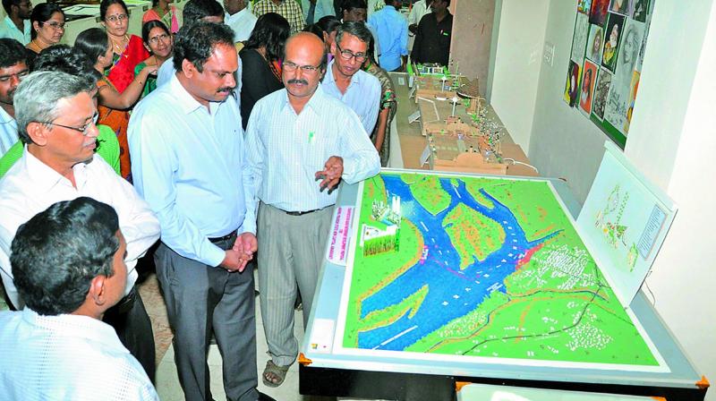 APCRDA commissioner Ch. Sreedhar, along with Acharya Nagarajuna University Vice-Chancellor Prof. A.Rajendra watches the models displayed at Anubhoothi - 2016 at Acharya Nagrajuna University in Guntur district on Friday. (Photo: DC)
