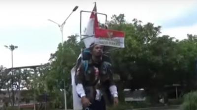 He walks backwards with the help of a headpiece built with plastic pipes, fixed with a rear-view mirror which allows him to walk backwards. (Photo: Screengrab/Metro TV)