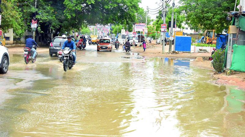 Motorists wades through rain water at Manikonda road on Saturday.