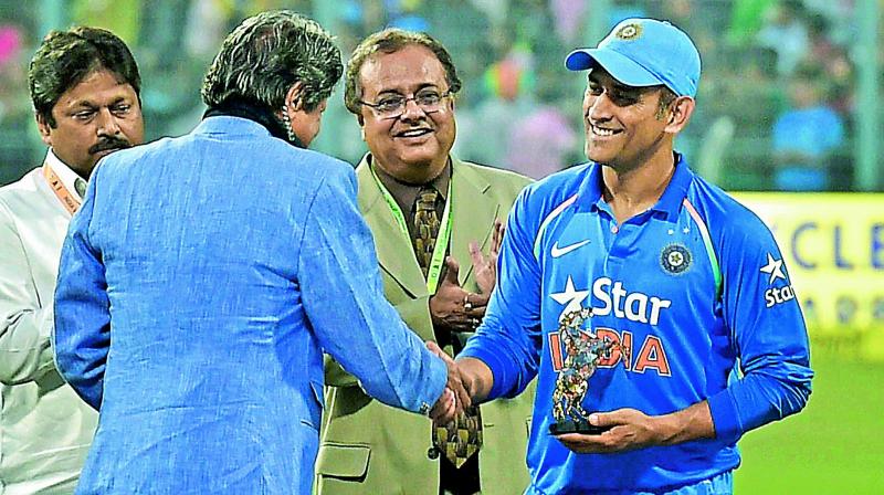 M.S. Dhoni is felicitated by former India captain Kapil Dev at the Eden Gardens during the innings break of the third one-day match against England.