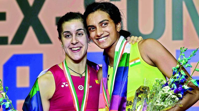 P. V. Sindhu (right) poses alongside Carolina Marin after winning the womens singles final of the Yonex-Sunrise India Open Superseries badminton tournament in New Delhi on Sunday. Sindhu beat Marin 21-19, 21-16. (Photo: AP)