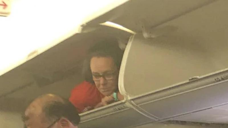 Passenger spots flight attendant inside overhead bin; see pics
