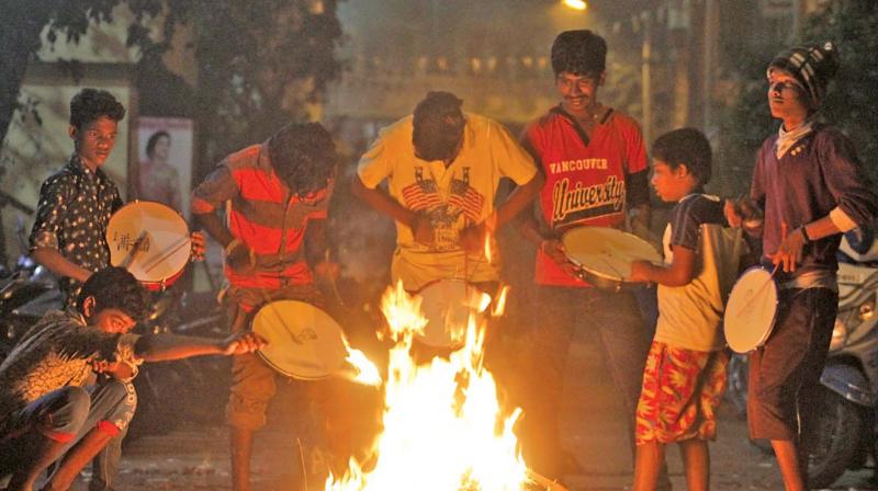 Early Friday morning, young boys feed a bonfire with old material while others beat handmade drums to announce onset of Bhogi at Padi. 	(Photo: DC)