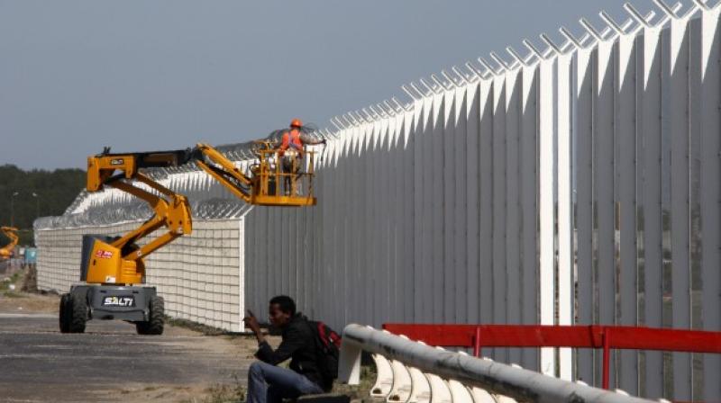 Workers install fences at the ferry port in Calais. (Photo: AP)