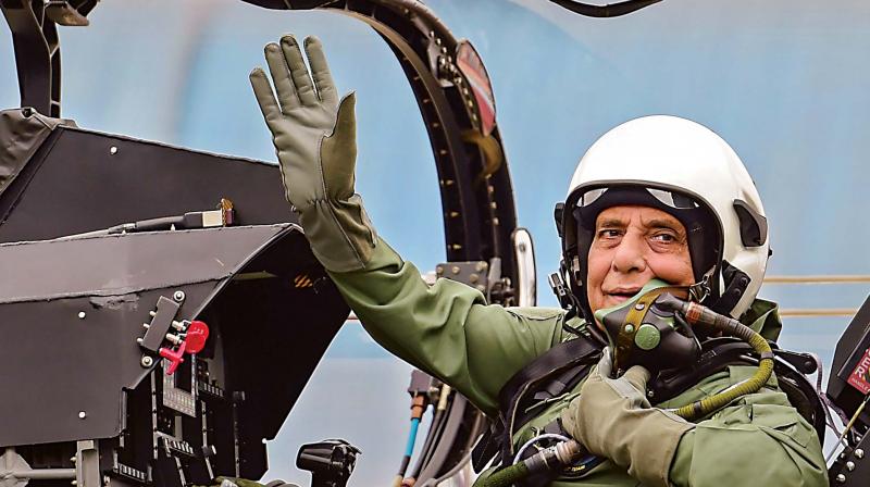 Defence Minister Rajnath Singh waves from the cockpit of a light combat aircraft Tejas before a sortie at HAL airport in Bengaluru on Thursday (Photo: AP)