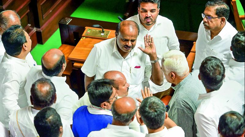 Karnataka Chief Minister H.D. Kumaraswamy discusses with his Cabinet colleagues after Assembly was adjourned for lunch in Bengaluru on Friday.  (PTI)