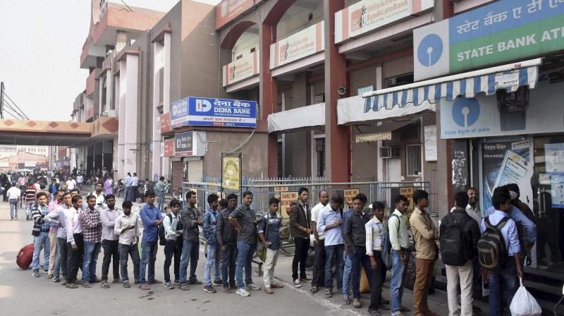 People stand in a long queue to withdraw money at an ATM in Patna. (Photo: PTI)