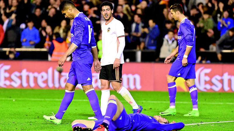 Real Madrids Casemiro (left), Gareth Bale (on the ground) and Cristiano Ronaldo (right) react after their 1-2 defeat to Valencia in their La Liga match at the Mestalla Stadium in Valencia on Wednesday. (Photo: AFP)