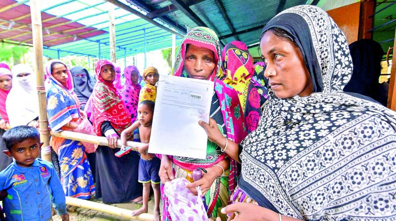 People wait to check their names on the final draft of the National Register of Citizens after it was released, at an NRC Seva Kendra in Nagaon, Assam on Monday.  (Photo:PTI)