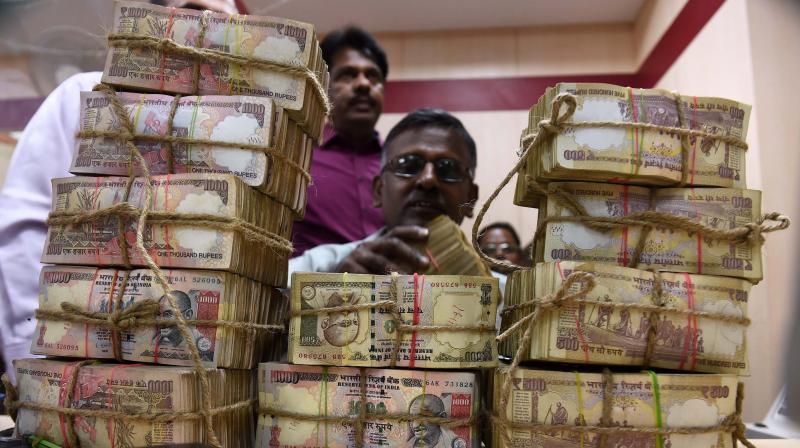 A bank employee counting the bundles of the received currency of old 1000 & 500 notes at cash counter at a Punjab National Bank branch in Chennai. (Photo: PTI)