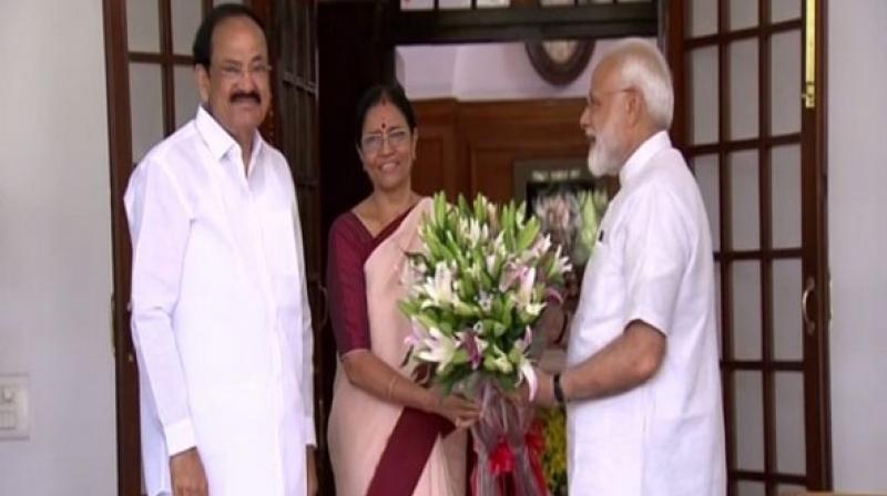 Wearing a white kurta and churidar with a yellow stole around his neck, Prime Minister Modi was welcomed with a bouquet of lilies by the Vice-Presidents wife M Usha. (Photo: ANI)