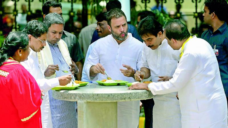 Congress vice-president Rahul Gandhi and Karnataka Chief Minister Siddaramaiah eating food at the newly launched Indira Canteen in Bengaluru. (Photo: PTI)