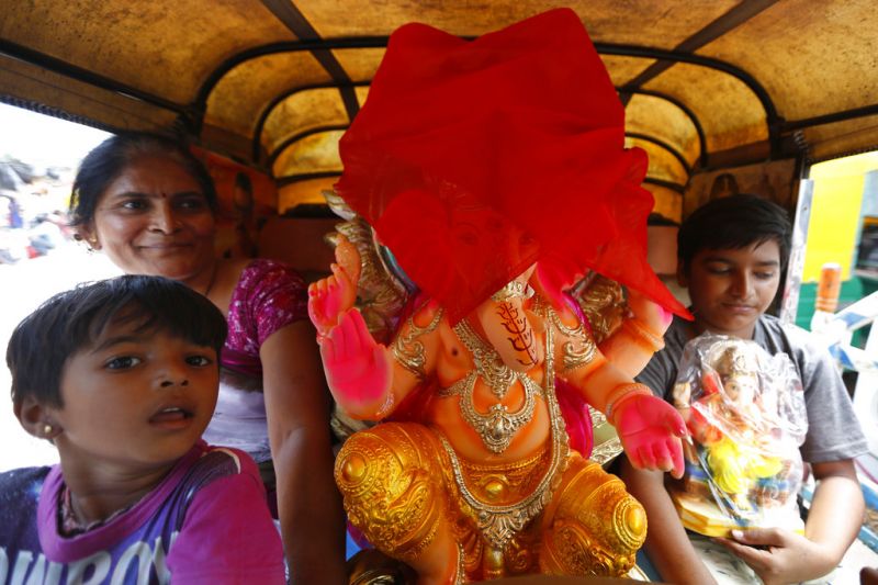 Devotees transport an idol of elephant-headed Hindu God Ganesha home in an auto for worship during Ganesh Chaturthi festival in Ahmadabad. (Photo: AP)