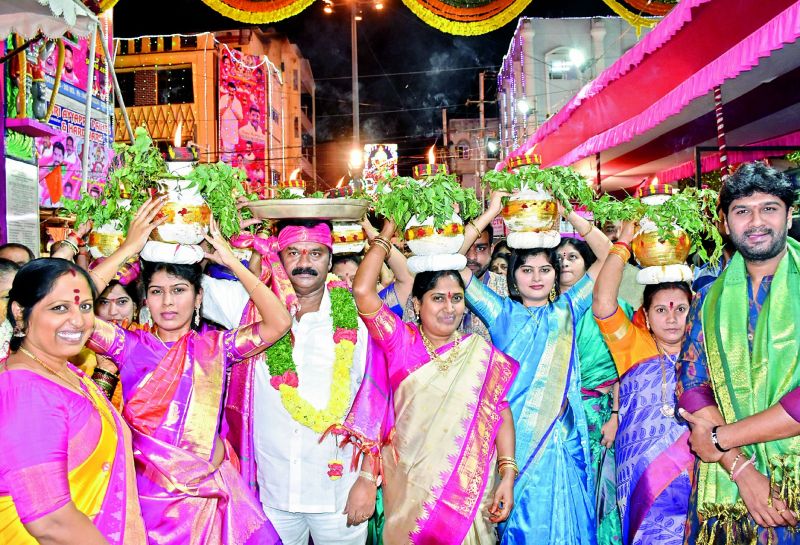 Minister Talasani Srinivas Yadav with family and others at Bonalu festival at Ujjaini Mahankali Temple in secunderabad. 	 DC