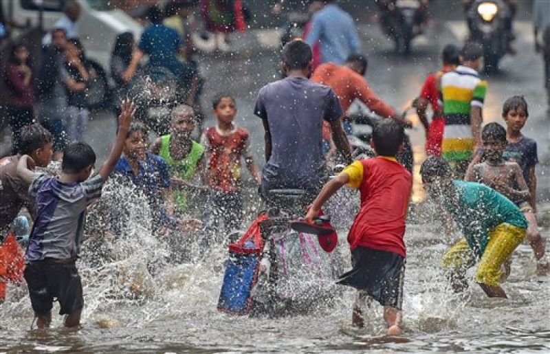 Mumbai rains: Children play on a water-logged street in Sion caused due to heavy downpour. (Photo: PTI)