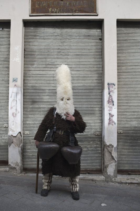 A man wearing a mask that includes a meter- tall, ribbon-covered formation topped with a foxtail. (Photo: AP)