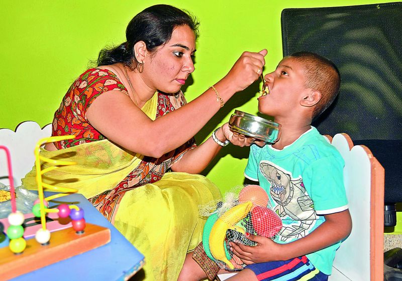 Special educator Shravanthika feeding a student 