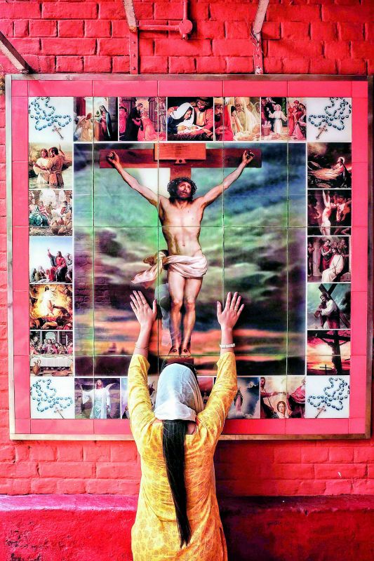 A woman worships Jesus Christ in the Anglo Indian locality of Bow Barracks in Kolkata.