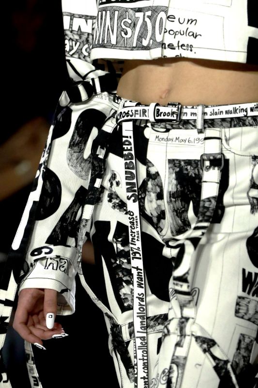 Model adoned belt with tabloid news headline. (Photo: AP)