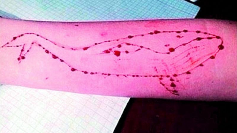  Players use a knife to draw the pattern of a whale on forearms with blood 