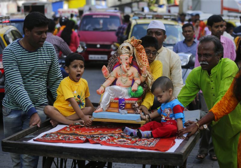 Devotees carry a Ganesh idol home on a cycle-rickshaw for worship during Ganesh Chaturthi festival celebrations in Mumbai. (Photo: AP)