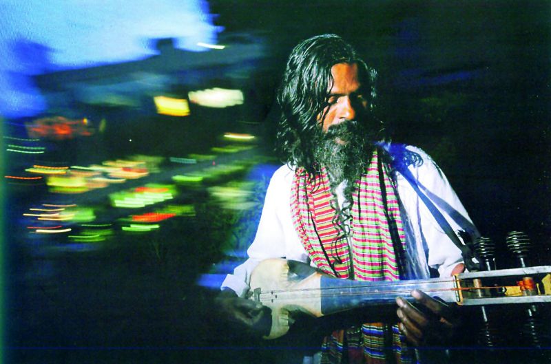 A Baul fakir sings on a rooftop above the light and noise of Bangladesh's capital Dhaka