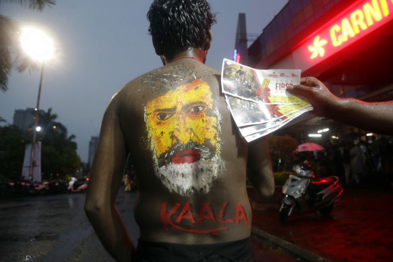 A man with the face of superstar Rajinikanth painted on his back poses for a picture outside a cinema hall before watching Rajinikanth's new movie 'Kaala' in Mumbai. (Photo: AP)