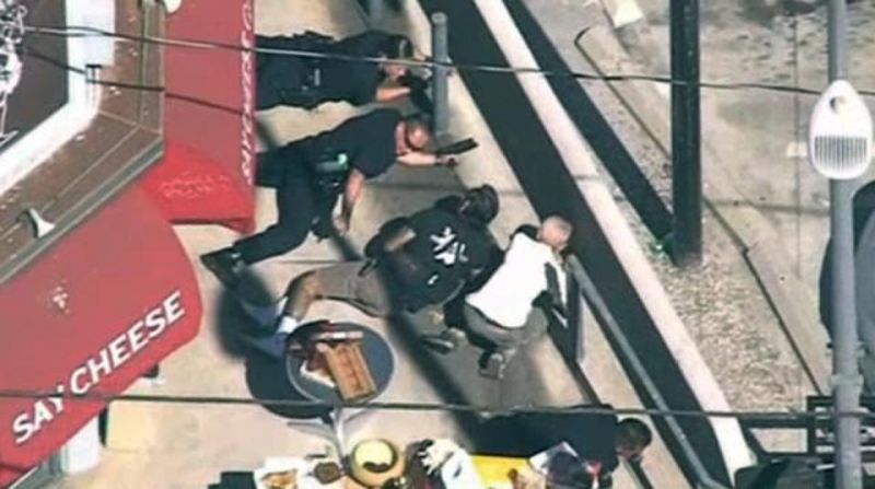 In this image from video provided by KNBC-TV, police and civilians take cover near the Trader Joe's supermarket. (Photo: AP)