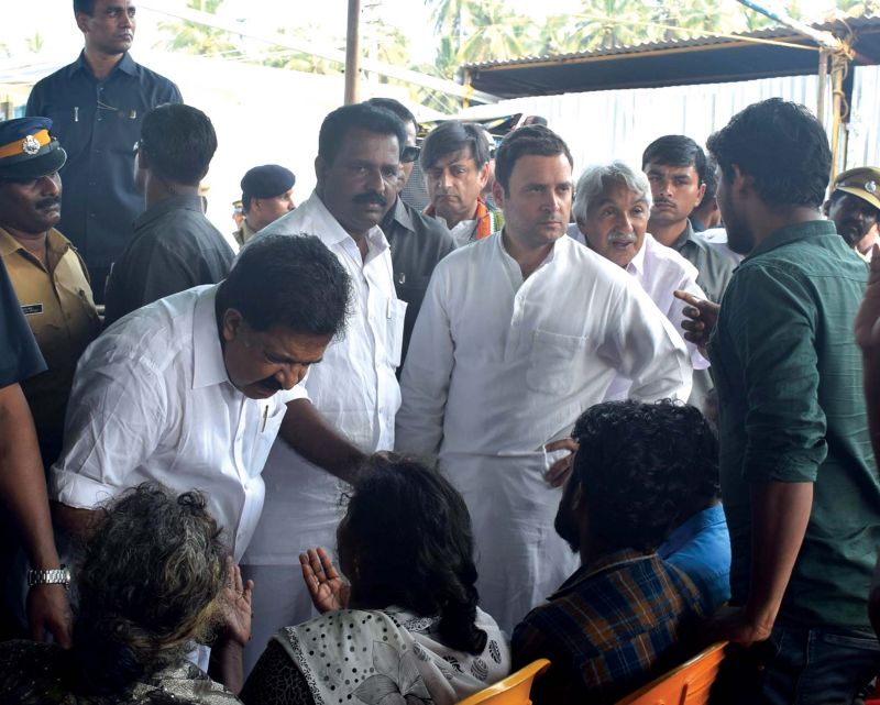 Congress president Rahul Gandhi and Opposition leader Ramesh Chennithala interact with the victims of Cyclone Ockhi in Thiruvananthapuram. 	(Photo: DC FILE)