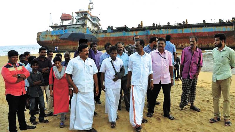 Members of Legislative Assembly panel along with residents of Kakkathoppu during their visit on Wednesday. The breached ship is seen in the background. (Photo: DC)