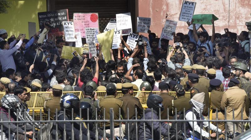 Policemen guard as All India Students Association (AISA) and Jawaharlal Nehru University students hold a protest demanding the arrest of Akhil Bharatiya Vidyarthi Parishad (ABVP) members at the police headquarters in New Delhi. (Photo: PTI)