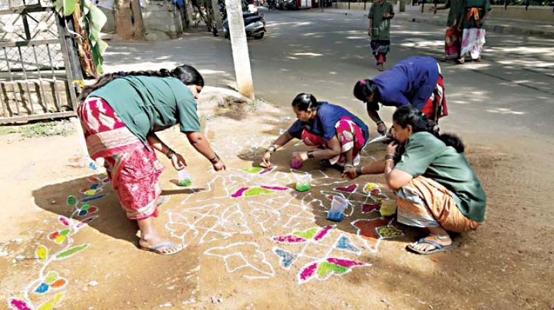 Pourkarmikas draw rangolis during the blackspot elimination drive at Jayanagar.