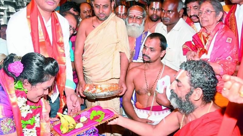 Seer Chinna Jeeyar Swami gives prasadam to Kanakadurga temple EO V. Koteswaramma in Vijayawada on Saturday. (Photo: Deccan chronicle