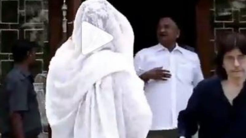 Screenshot from video where Rekha hides herself from the camera.