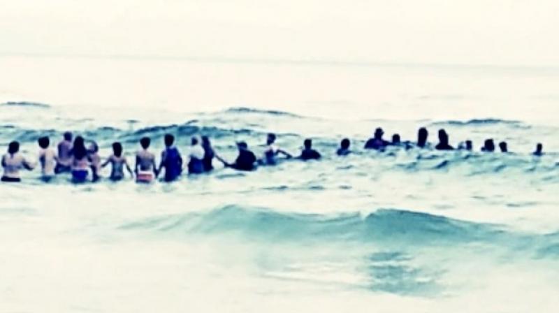 80 strangers helped rescue 10 people that had been swept away by a powerful riptide. (Photo: Youtube)