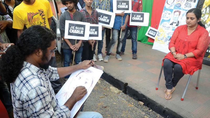 An artist draws caricature of a model during an event at Manaveeyam road in Thiruvananthapuram. 	 	(File pic)