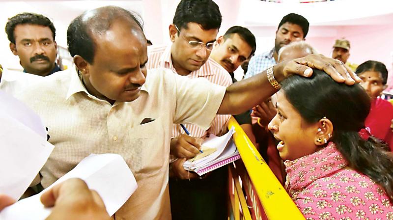 Chief Minister H.D. Kumaraswamy listens to the grievances of a tearful woman during his visit to Ramanagara on Monday  (Photo:  KPN )