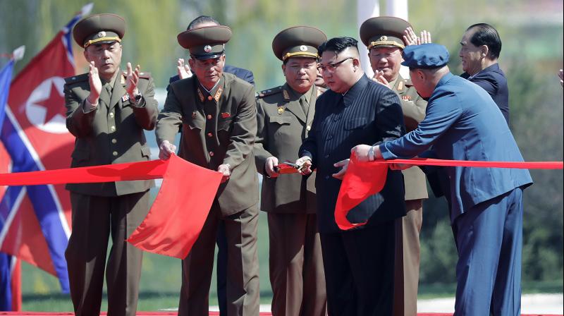 North Korean leader Kim Jong Un, fourth right, stands with officials as he cuts the ribbon at the official opening of the Ryomyong high-rise district, in Pyongyang, North Korea. (Photo: AP)