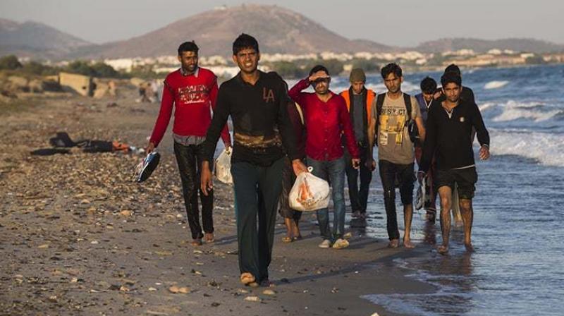 Migrants from Pakistan walk on a beach after rowing on a dinghy from the Turkish coasts to the Greek Island of Kos. (Photo: AP/ File)