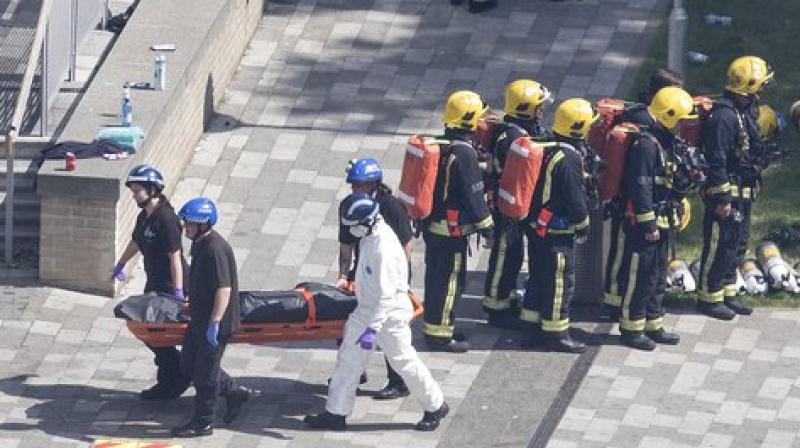 Bodies are removed from the scene after a fire engulfed the 24-storey Grenfell Tower. (Photo: AP)